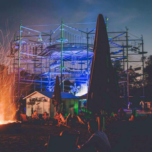 Ein beleuchtetes Freiluftkonzert mit einer großen Bühne, Feuerwerk und einem Publikum im Vordergrund.